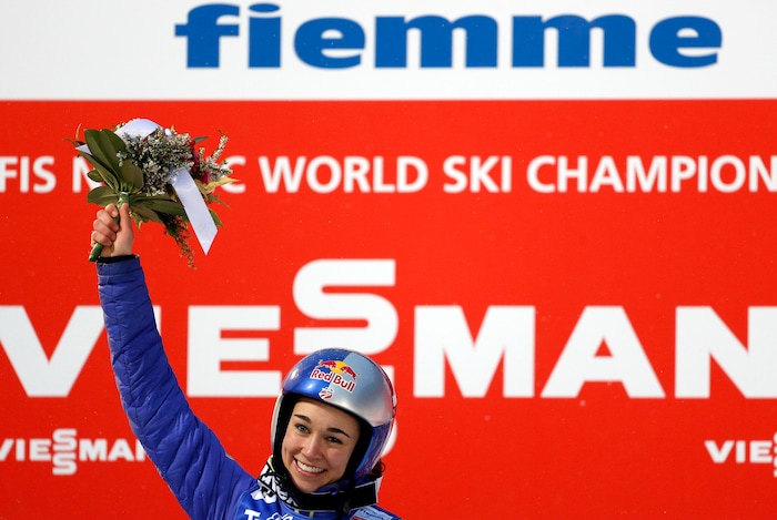 Sarah Hendrickson of the United States celebrates on the podium after winning the women's ski jumping HS 106 Individual at the Nordic Ski World Championships in Val di Fiemme, Italy, Friday, Feb. 22, 2013.  (AP Photo/Matthias Schrader)