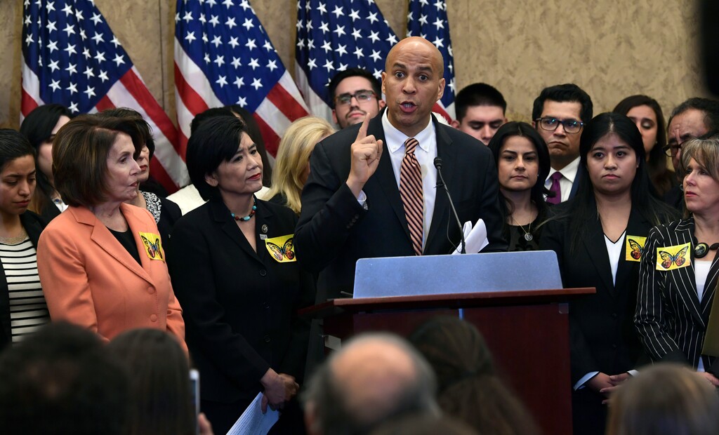 Sen. Cory Booker, D-N.J., center, speaks during a news conference on Capitol Hill in Washington, Tuesday, Jan. 30, 2018, about legislation to protect Deferred Action for Childhood Arrivals program recipients. House Minority Leader Nancy Pelosi of California listens at left. (AP Photo/Susan Walsh)