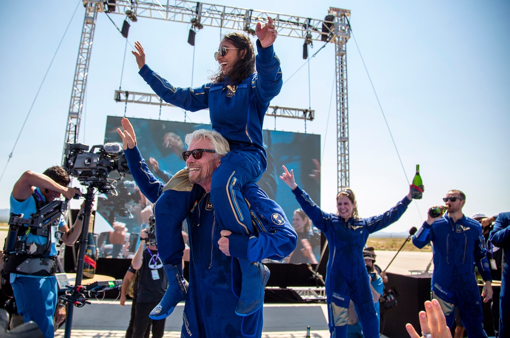 (Andres Leighton | The Associated Press) Virgin Galactic founder Richard Branson carries crew member Sirisha Bandla on his shoulders while celebrating their flight to space at Spaceport America near Truth or Consequences, N.M., Sunday, July 11, 2021.