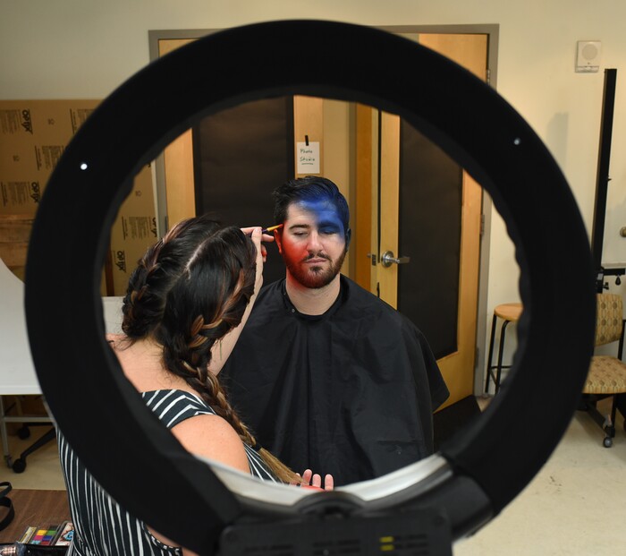 (Francisco Kjolseth | The Salt Lake Tribune) Makeup artist Kristen Packard works her magic on Brad Klekas of South Jordan, a BYU and Utah fan alike as he's willing to show his mutual admiration of both teams by stepping into the Tribune studio to get both colors in anticipation of the upcoming match up between the two rival teams on Saturday.