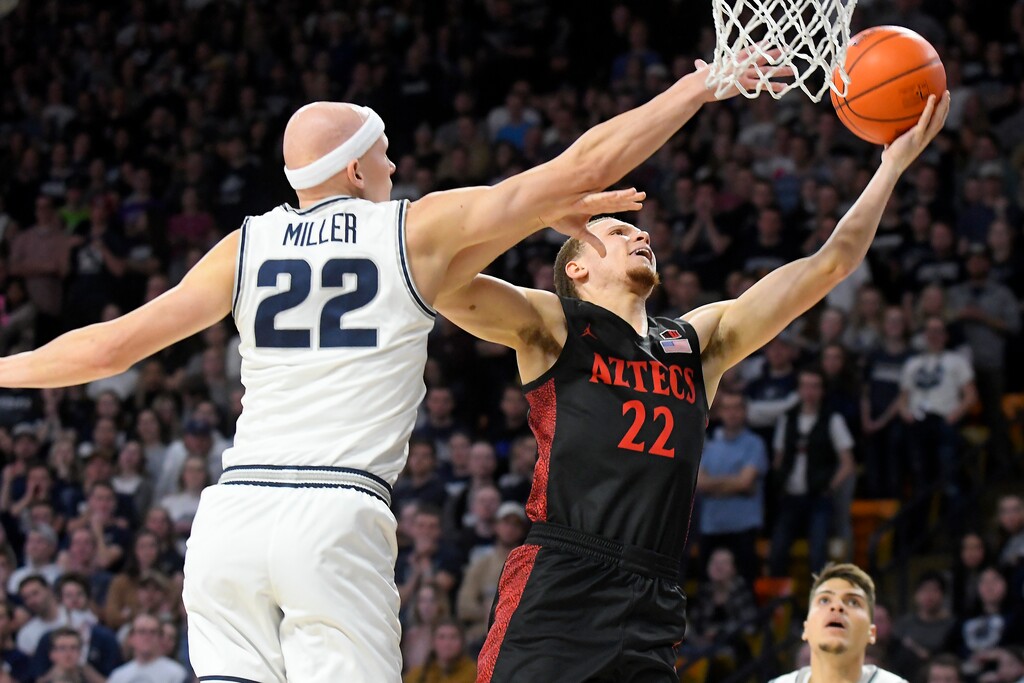 San Diego State guard Malachi Flynn, right, shoots as Utah State guard Brock Miller defends during the first half of an NCAA college basketball game Saturday, Jan. 4, 2020, in Logan, Utah. Miller will return for an Aggies team that will begin its pursuit of the Mountain West title on Dec. 29, 2020. The Aggies will host SDSU at the Spectrum on Jan. 16, 2021. (AP file Photo/Eli Lucero)