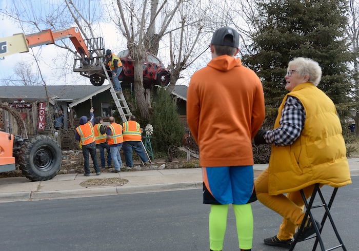 (Al Hartmann | The Salt Lake Tribune)
Clearfield public works personnel use a crane to remove Janis Zettel's gutted VW Beetle from a tree in her front yard Tuesday Feb. 13. She put it up a few months ago as an art installation. Now it has to come down. Zettel watches the operation with her grandson Fischer Grant from the street.