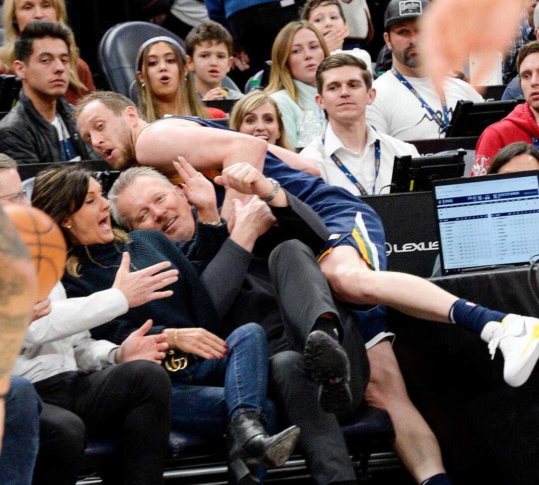 (Leah Hogsten  |  The Salt Lake Tribune) Utah Jazz forward Joe Ingles (2) lands on Greg Miller and his wife Heidi Miller chasing a loose ball as the Utah Jazz host the Golden State Warriors, Dec. 13, 2019 at Vivint Arena.