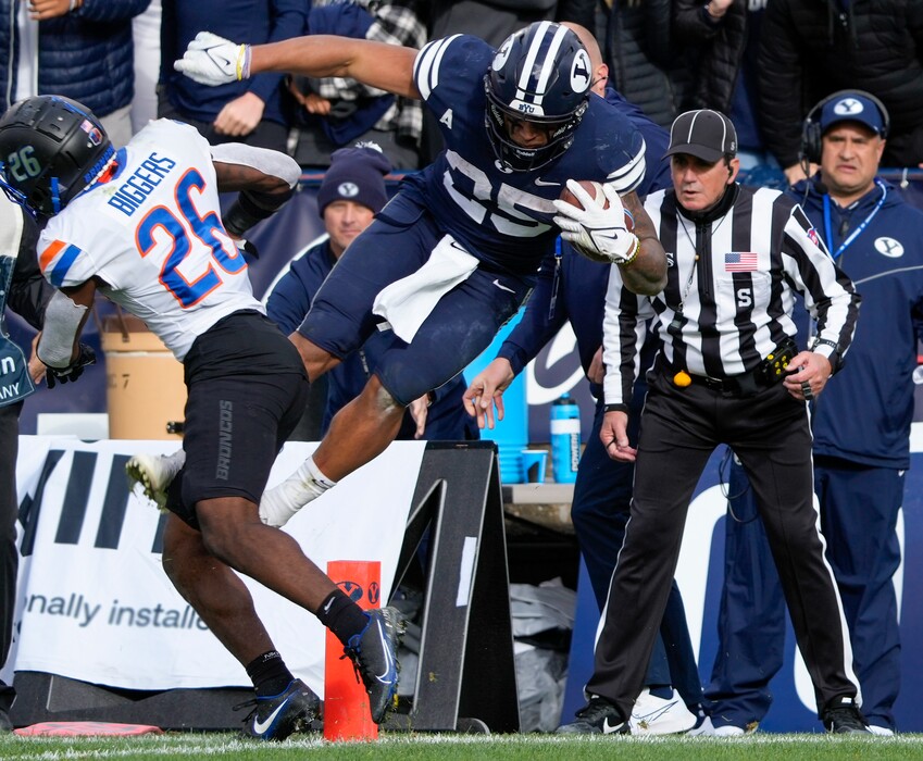 (Leah Hogsten | The Salt Lake Tribune) Brigham Young Cougars running back Tyler Allgeier (25) just misses the goal leaping past Boise State Broncos cornerback Caleb Biggers (26) as No. 10 Brigham Young University hosts Boise State at LaVell Edwards Stadium, Oct. 9, 2021.