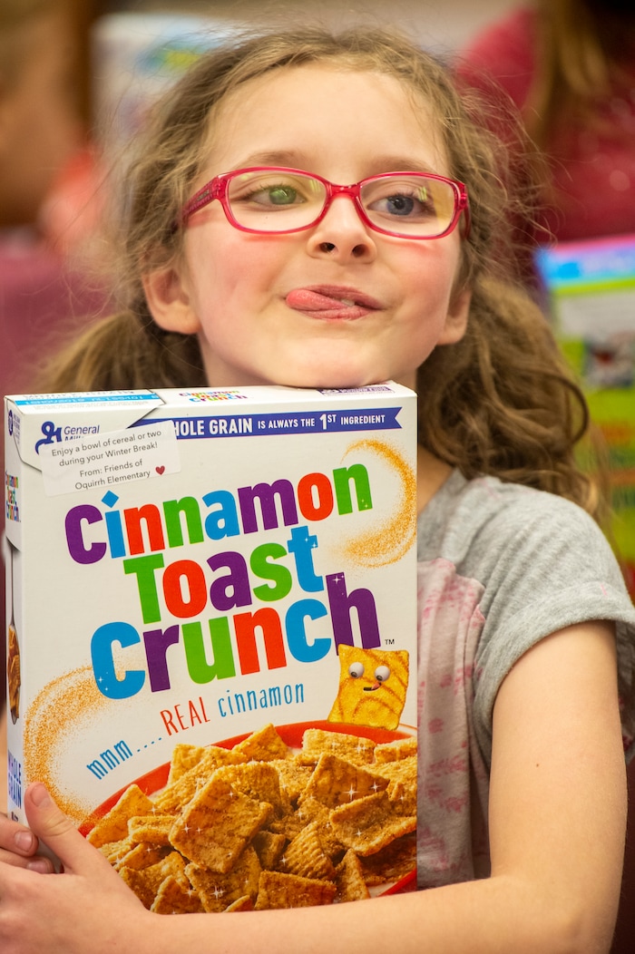 (Rick Egan  |  The Salt Lake Tribune)   Lonna Slack, 3rd grade, poses for photo with her box of cereal. Ms. Worthington the principal, surprised all 650 students at her school with the gift-wrapped boxes of cereal, at Oquirrh Elementary in West Jordan, Thursday, Dec. 20, 2018.


