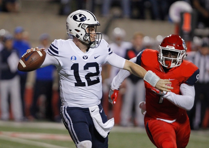 BYU's Tanner Mangum tries to complete a pass as Fresno State's Jeffrey Allison chases during the first half of an NCAA college football game in Fresno, Calif., Saturday, Nov. 4, 2017. (AP Photo/Gary Kazanjian)