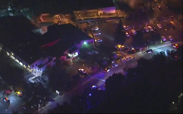 In this image made from aerial video, police vehicles line a road in the vicinity of a shooting in Thousand Oaks, California, early Thursday, Nov. 8, 2018.  Authorities say there were multiple injuries _ including one officer _ after a man opened fire in Southern California bar late Wednesday. (KABC via AP)