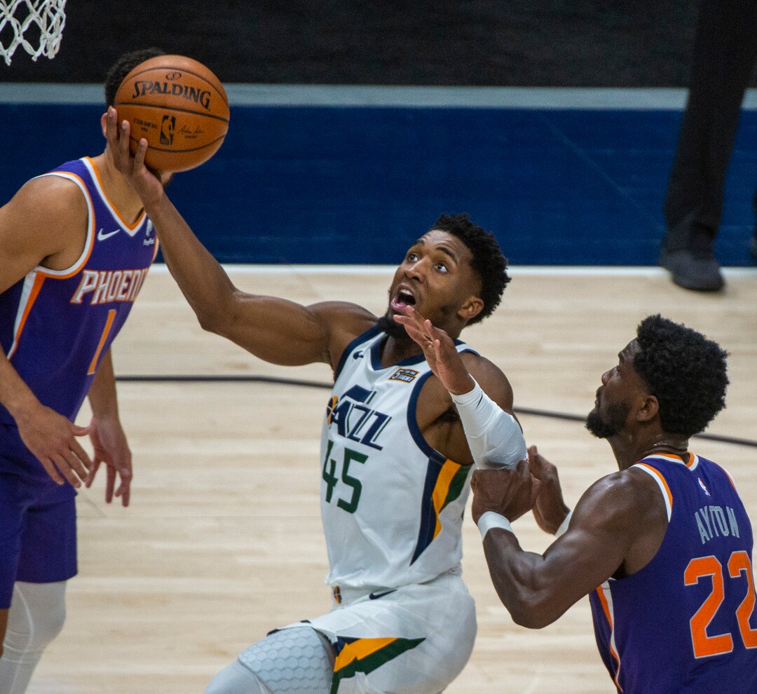 (Rick Egan | The Salt Lake Tribune) Utah Jazz guard Donovan Mitchell (45) takes the ball to the hoop. As Phoenix Suns Phoenix Suns center Deandre Ayton (22) defends, in preseason NBA action between Utah Jazz and Phoenix Suns at Vivint SmartHome Area, on Saturday, Dec. 12, 2020.