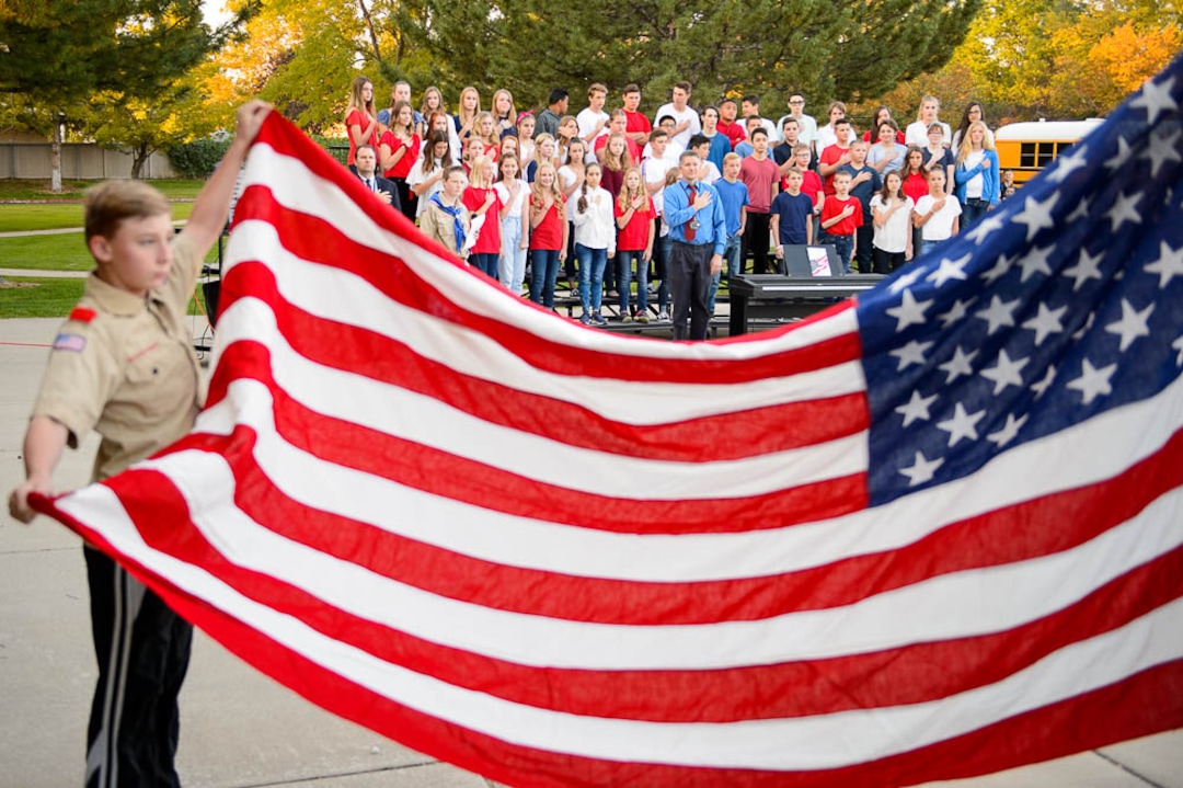 (Trent Nelson | The Salt Lake Tribune)  Students in the South Jordan Middle School Concert Choir look on as boy scouts raise the flag at sunrise to mark the anniversary of 9/11, Tuesday Sept. 11, 2018.