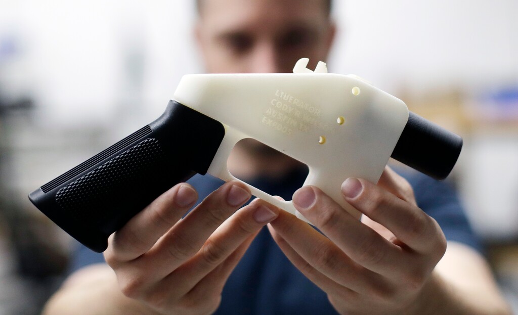 (AP Photo/Eric Gay, file) In this Aug. 1, 2018, file photo, Cody Wilson, with Defense Distributed, holds a 3D-printed gun called the Liberator at his shop in Austin, Texas. A federal judge in Seattle has granted an injunction that prohibits the Trump administration from allowing a Texas company to post 3D gun-making plans online.