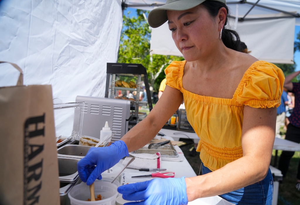 (Bethany Baker  |  The Salt Lake Tribune) Chin Malin, the owner of S.A.L.T. Suburban Kitchen, prepares an order at her booth at the Downtown Farmer's Market in Salt Lake City on Saturday, June 29, 2024.