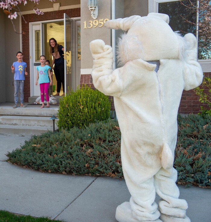 (Rick Egan  |  The Salt Lake Tribune)     Jayna, Lizzie, Charlotte Cole wave at the Easter Bunny, from their front porch in Draper. Draper City Parks and Recreation workers along with the police and the fire department, delivered more than 30,000 Easter eggs to children at their doorsteps, Friday, April 10.