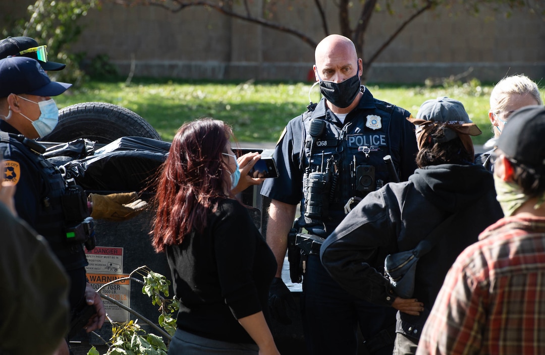 (Francisco Kjolseth  |  The Salt Lake Tribune) Police are confronted by homeless advocates as the Salt Lake County Health Department forces a clean up of homeless camps set up near Taufer Park in Salt Lake City on Thursday, Sept. 10, 2020.