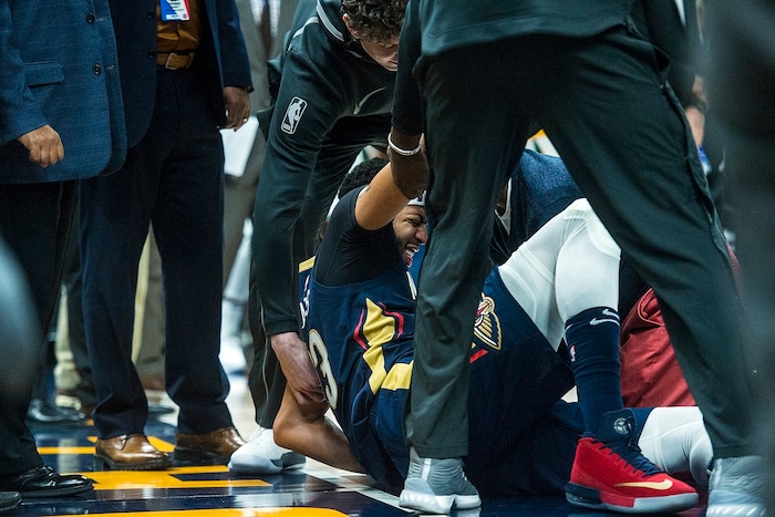 (Chris Detrick  |  The Salt Lake Tribune)  New Orleans Pelicans forward Anthony Davis (23) is helped off of the court after getting injured during the game at Vivint Smart Home Arena Friday, December 1, 2017.  Utah Jazz defeated New Orleans Pelicans 114-108.