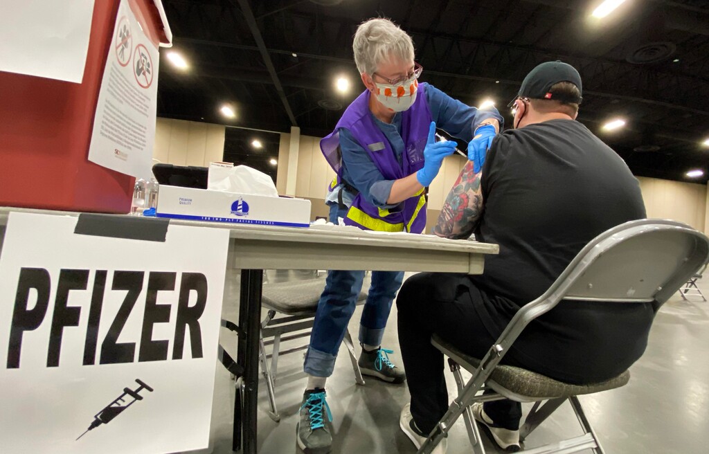 (Rick Egan | The Salt Lake Tribune)  Irene Stukshis administers the Covid -19 vaccine to Stephan Rich, at the Mountain America Expo site in Sandy on Monday, March 8, 2021.