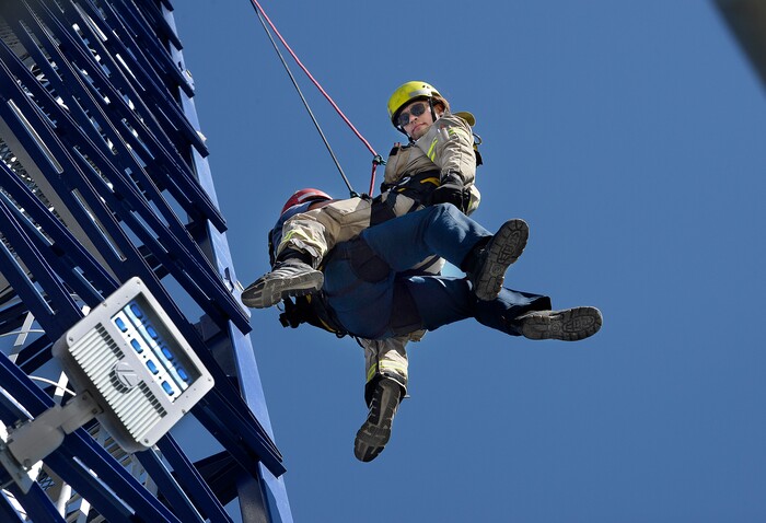 (Scott Sommerdorf | The Salt Lake Tribune) Firefighter Rob Takeno, top, of the Park City Fire District special operations team practices a tower crane operator rescue with firefighter Steve Jensen, left, acting as the victim, as they are slowly lowered to the ground. The high mountain rescue training exercise utilized a Jacobsen tower crane and operator at the construction site of the One Empire Pass development at Deer Valley, Sunday, Aug. 20, 2017.