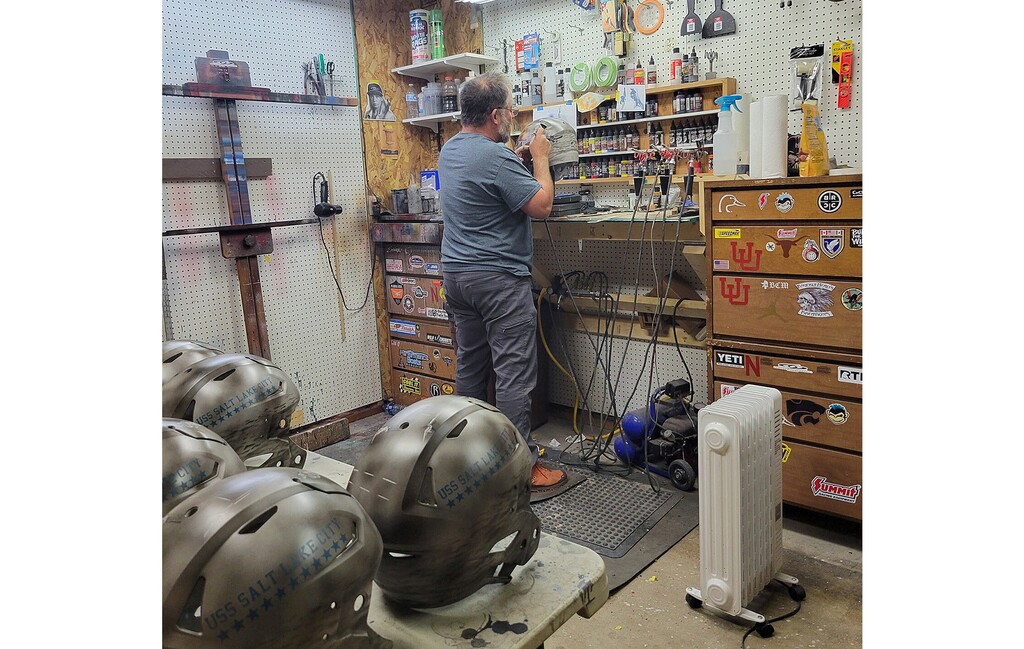 (Armando Villareal) Armando Villareal works on special airbrushed helmets for the Utah football team in his studio in Imperial, Neb. The team will wear the helmets on Saturday representing the USS Salt Lake City, a heavy cruiser in World War II.