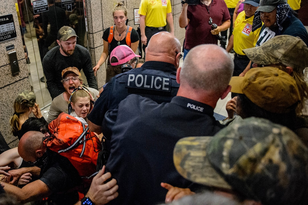 (Trent Nelson  |  The Salt Lake Tribune)  Police wade in to remove protesters occupying the Chamber of Commerce Building Salt Lake City on Tuesday, July 9, 2019. Dozens of people showed up to protest the planned Inland Port. The protest began at City Hall and moved to the Chamber of Commerce.