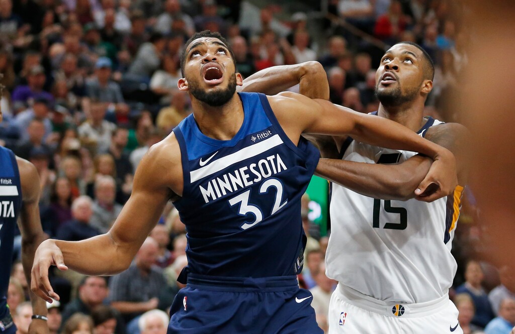 Minnesota Timberwolves center Karl-Anthony Towns (32) and Utah Jazz forward Derrick Favors (15) battle under the boards for a rebound in the second half during an NBA basketball game Monday, Nov. 13, 2017, in Salt Lake City. (AP Photo/Rick Bowmer)