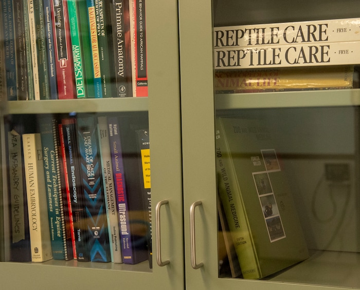 (Rick Egan  |  The Salt Lake Tribune)    Reference books in a bookcase in the exam room in the Hogle Zoo's Animal Health Center. Saturday, March 16, 2019.


