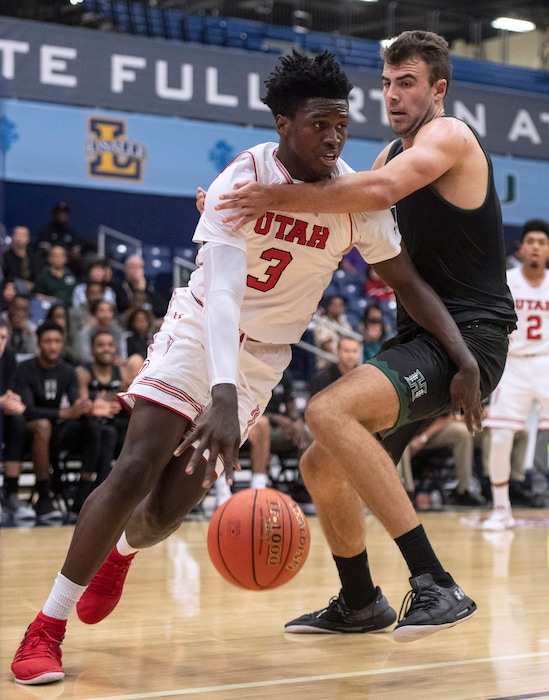 Utah forward Donnie Tillman, left, drives toward the basket past Hawaii center Mate Colina during the first half of an NCAA college basketball game at the Wooden Legacy tournament Thursday, Nov. 22, 2018, in Fullerton, Calif. (AP Photo/Kyusung Gong)