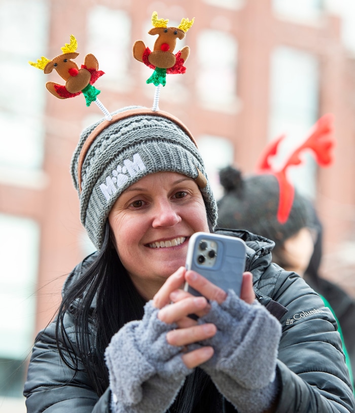 (Rick Egan  |  The Salt Lake Tribune)    Volunteer, Jenny Espindola takes photos of owners with their pets, at the Street Dawg Crew Christmas outreach at Liberty Park Sunday.  The Street Dawg Crew supports the homeless and their pets every Sunday at Pioneer Park.  For today's Christmas Outreach, the Street Dawg Crew passed out food and gift bags for humans and animals, and also offered a photo opportunity with Santa. Sunday, Dec. 22, 2019.