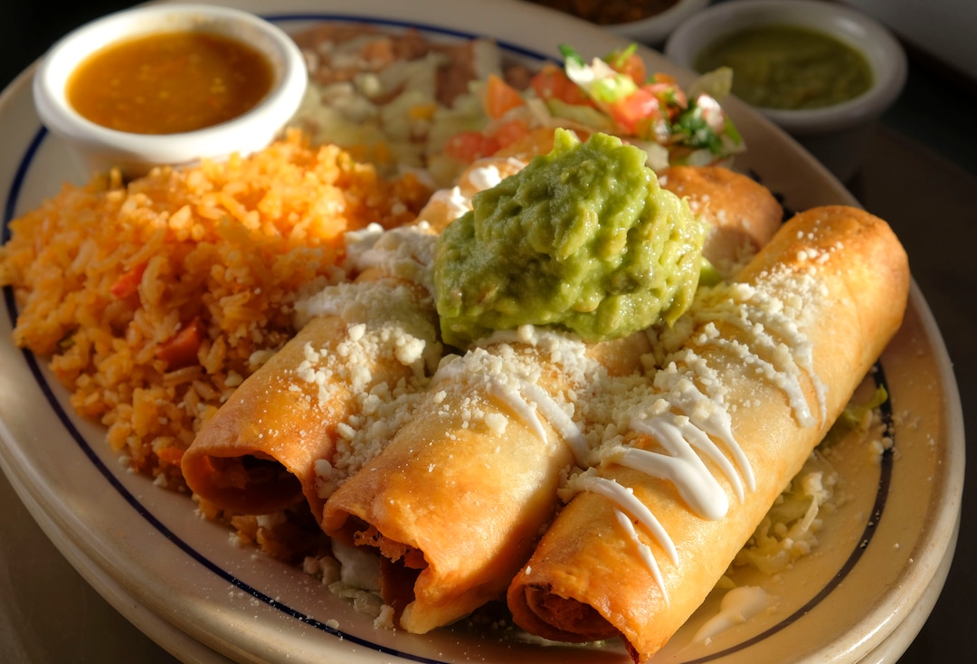 (Leah Hogsten  |  The Salt Lake Tribune) Rio Grande Cafe's taquitos filled with chicken, beef or pork with lettuce, guacamole, tomatillo sauce, cotija cheese and Mexican crema, served with rice and beans, $11.99. Salt Lake City's popular Rio Grande Cafe, which has been closed since March due to the pandemic and the earthquake, has moved to its new location near the University of Utah on 1300 East, Dec. 29, 2020.