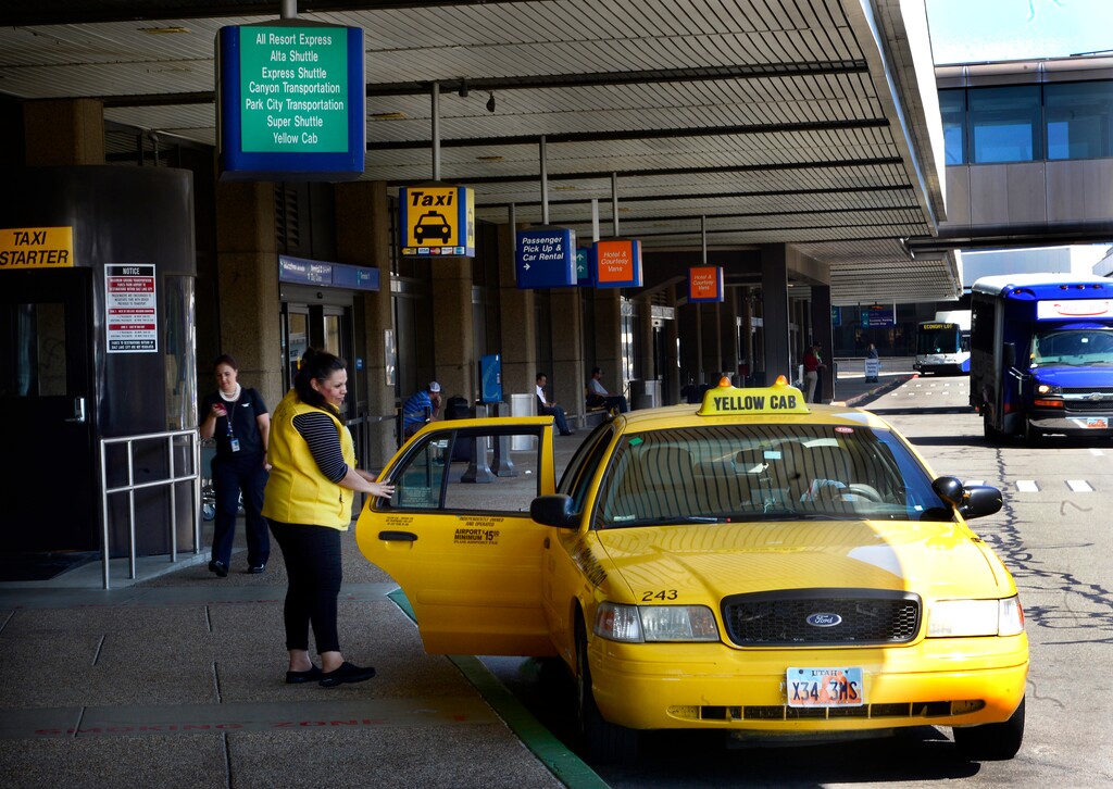 Scott Sommerdorf | The Salt Lake Tribune
Yellow Cab employee Elbia Rojas will walk a customer out to the cab they have ordered for them one of the two new Yellow Cab booths inside the terminal at Salt Lake City International Airport, Friday, August 19, 2016. Yellow, Ute and City cabs are no longer using the city's taxi stands at the airport. They say they have essentially been crowded out by the 400-plus other cab companies that appeared after deregulation there, and it isn't worth their time to be in the long queues.