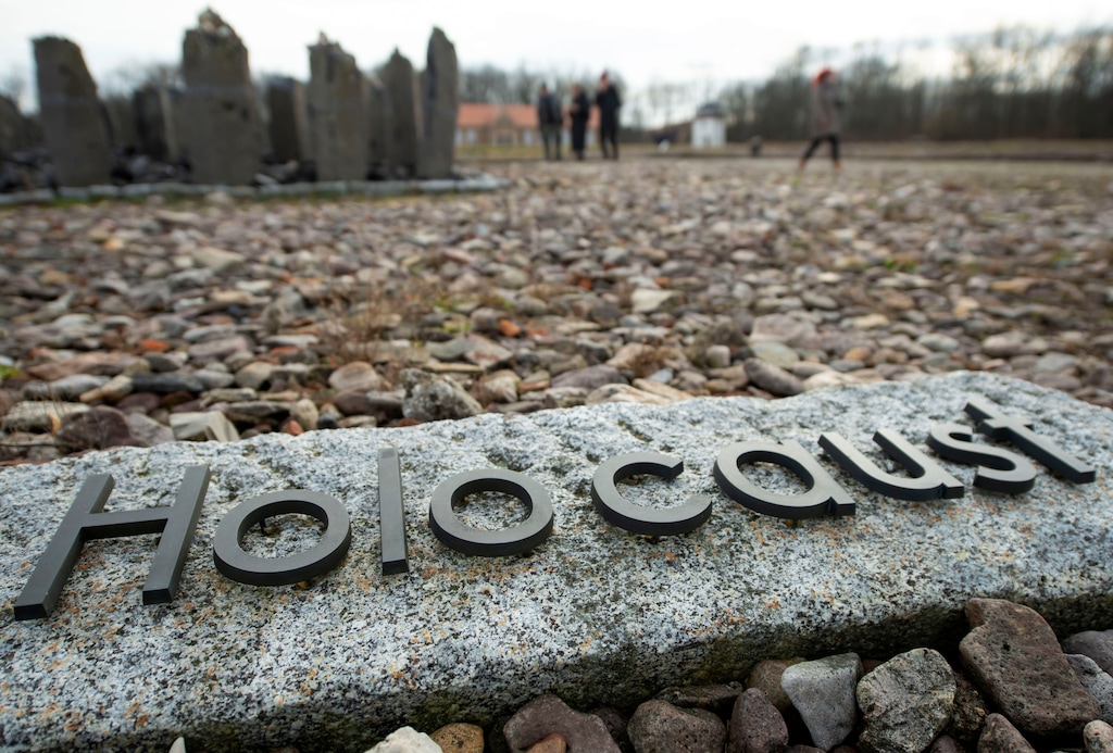 (AP Photo/Jens Meyer, file) In this Monday, Jan. 27, 2020, photo, people walk behind the writing "Holocaust" during the international Holocaust remembrance day in the former Nazi concentration camp Buchenwald near Weimar, Germany.