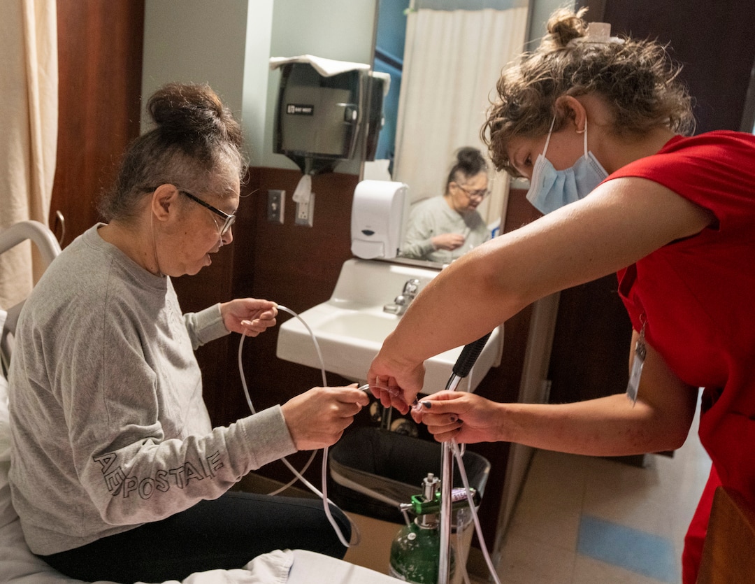 (Rick Egan | The Salt Lake Tribune) Heidi Weiler assists Tina Lewis as they prepare a portable oxygen tank so she can get some exercise in the halls of South Davis Community Hospital in Bountiful, on Tuesday, Sept. 21, 2021.