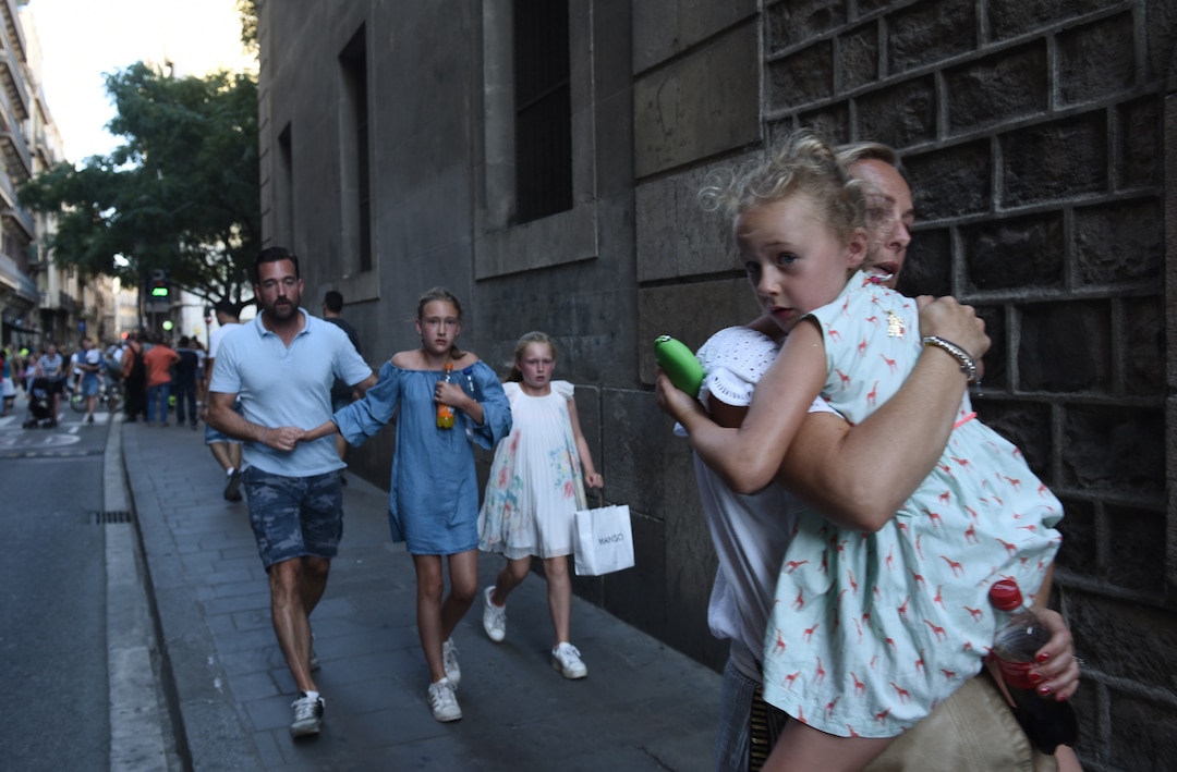 (Giannis Papanikos | The Associated Press) People flee the scene in Barcelona, Spain, Thursday, Aug. 17, 2017 after a white van jumped the sidewalk in the historic Las Ramblas district, crashing into a summer crowd of residents and tourists and injuring several people, police said.