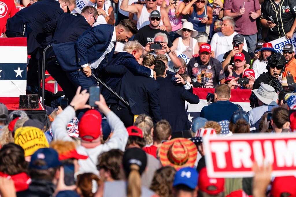 (Eric Lee | The New York Times) A bloodied Donald Trump is surrounded by Secret Service agents at a campaign rally in Butler, Pa, on Saturday, July, 13, 2024.