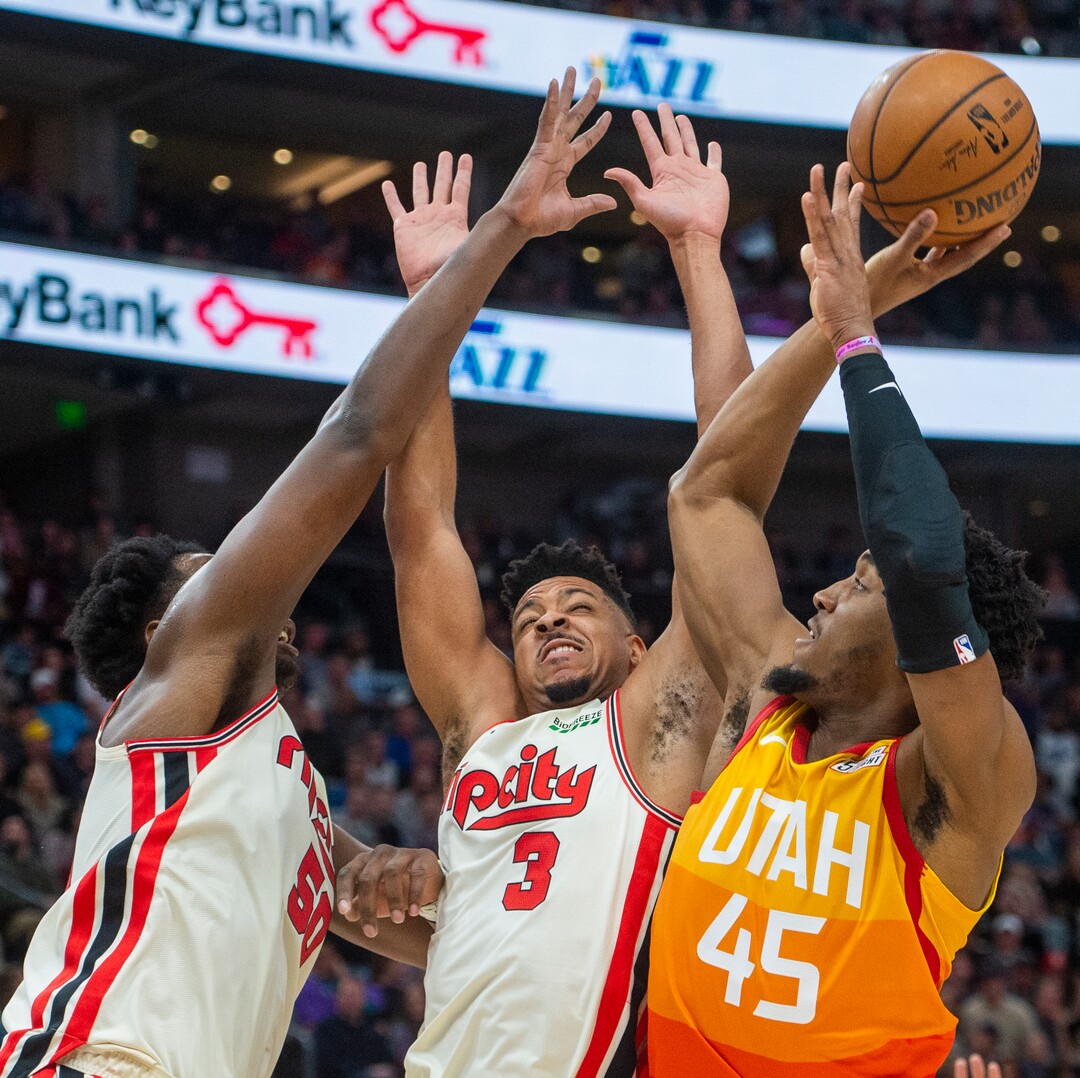 (Rick Egan  |  The Salt Lake Tribune)     Utah Jazz guard Donovan Mitchell (45) shoots over Portland Trail Blazers forward Caleb Swanigan (50) and Trail Blazer guard CJ McCollum (3) defends, in NBA action between the Utah Jazz and thePortland Trail Blazers in Salt Lake City, Friday, Feb. 7, 2020.