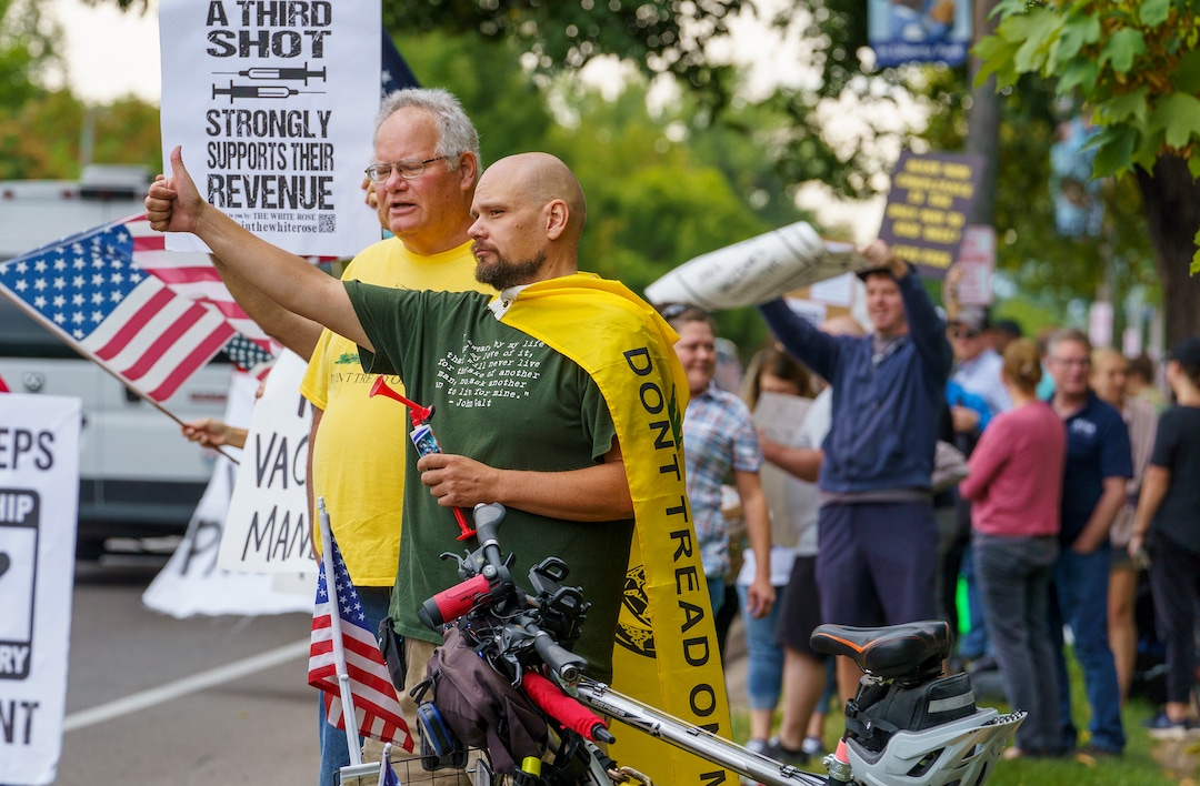 (Leah Hogsten | The Salt Lake Tribune) Protesters waving American flags and holding signs decrying mask and vaccine mandates gathered along the curb of 700 East in Liberty Park Saturday, making Salt Lake City one of dozens of cities around the world protesting public health-related restrictions, Sept. 18, 2021.