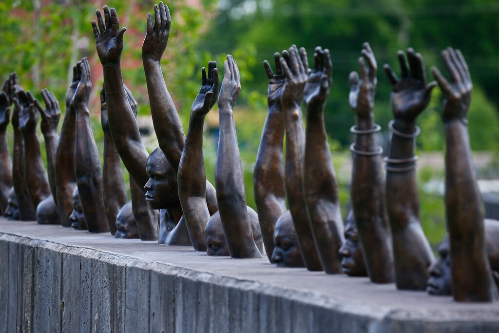This photo shows a bronze statue called "Raise Up", part of the display at the National Memorial for Peace and Justice, a new memorial to honor thousands of people killed in lynchings, Monday, April 23, 2018, in Montgomery, Ala. The memorial and an accompanying museum that open this week in Montgomery are a project of the nonprofit Equal Justice Initiative, a legal advocacy group in Montgomery. (AP Photo/Brynn Anderson)