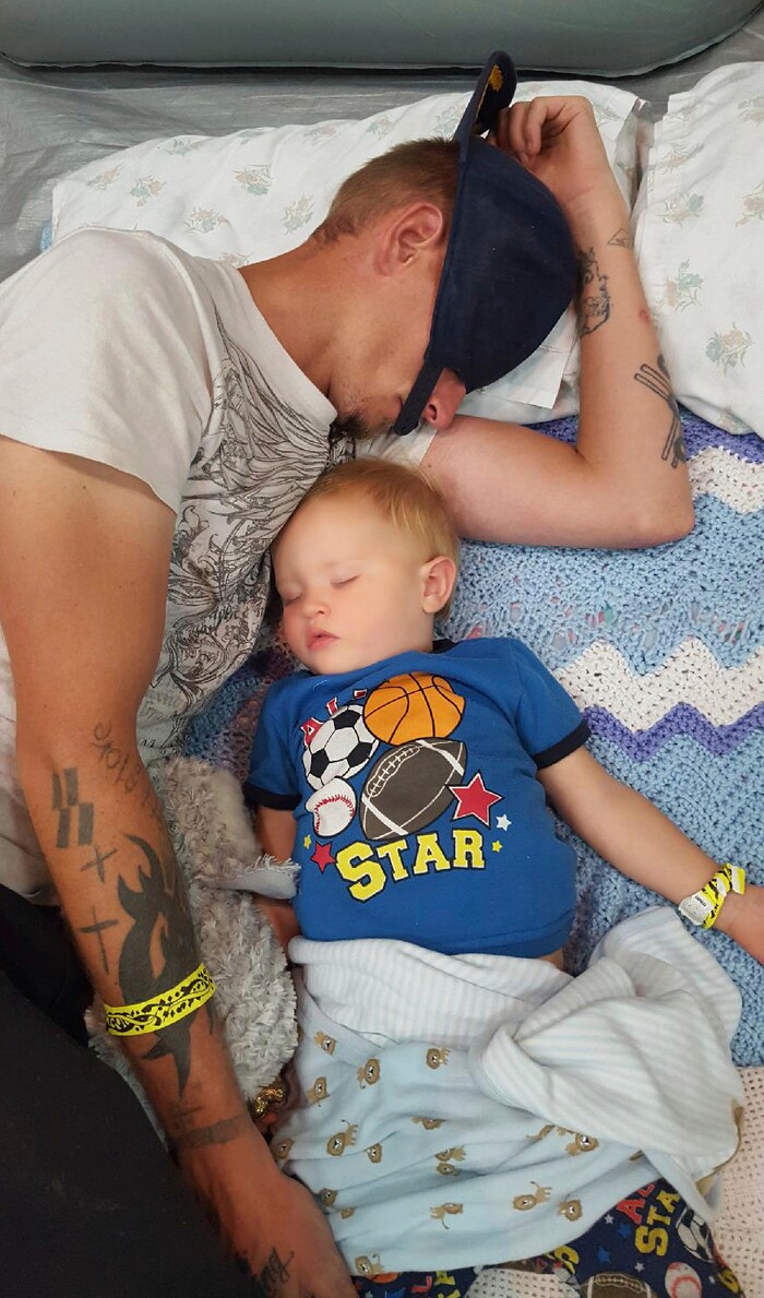 This undated mobile phone photo made available by Shelby Hoogendyk shows her husband Casey Huffman, with their 17 month-old son Caelan Hoogendyk at a hurricane shelter in St. Augustine, Fla. The family evacuated from a homeless shelter to a hurricane shelter during Hurricane Irma. When they arrived at the hurricane shelter, they were segregated from the rest of the evacuees and made to wear yellow wristbands. Advocates for the homeless say the ill treatment of homeless people during disasters is a national problem that reflects the lack of state and local emergency planning to deal with that population. (Shelby Hoodgendyk via AP)