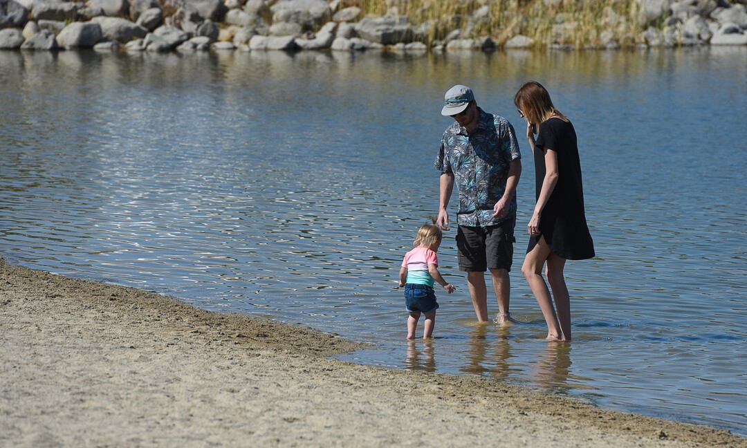 (Francisco Kjolseth  |  The Salt Lake Tribune)  Brian and McKenzie McDonald wander into Black Ridge Reservoir in Herriman with their daughter Penelope, 14-months, before being warned about the small warning signs posted at popular recreation site on Tuesday, Aug. 28, 2018, where an outbreak of algae-related toxin cyanobacteria was detected in the water.