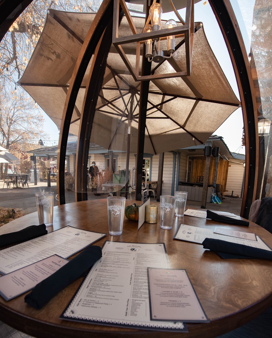 (Francisco Kjolseth  |  The Salt Lake Tribune) The dome-like Alpenglobes that allow diners to eat inside a warm environment, while also being separated from others have been added at Cafe Galleria in Midway as a table is set on Thursday, Nov. 5, 2020. The owners were trying to find a way to use their outdoor patio in the winter, teaming up with Insight Exhibit, a Salt Lake City corporate event company that was looking for a way to make money while large gatherings have been cancelled.