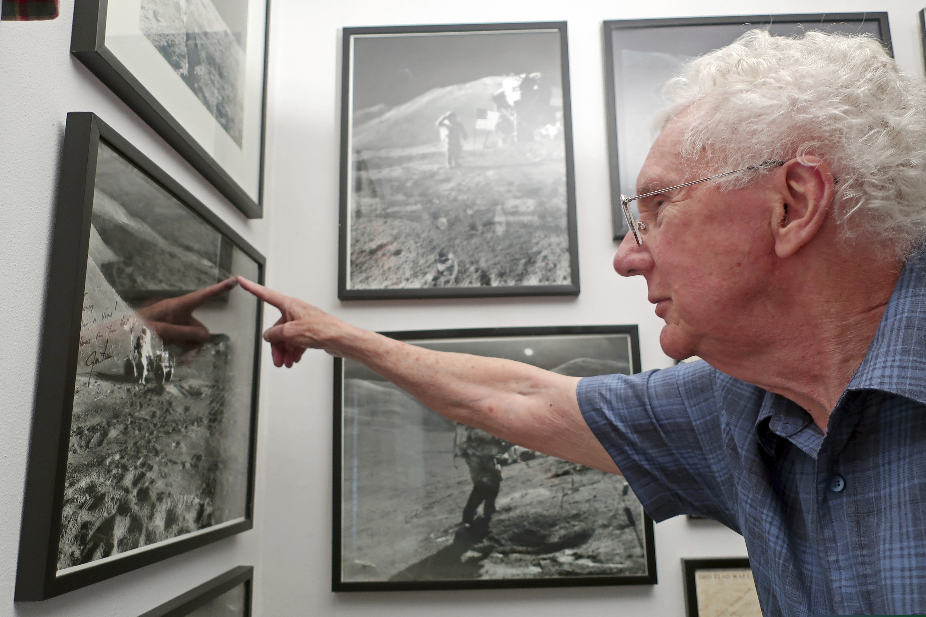 (Felicia Fonseca |AP) In this June 27, 2019 photo, Gerald Schaber, a former geologist with the U.S. Geological Survey's Astrogeology Science Center, points to a hill on the moon that bears his name in a photograph hanging in his Flagstaff, Ariz., office.