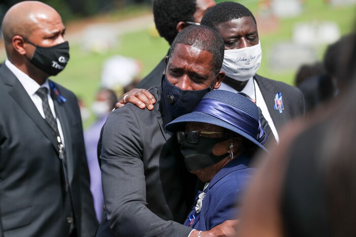 Family members embrace at the burial service for Rep. John Lewis at South-View Cemetery in Atlanta Thursday, July 30, 2020. (Alyssa Pointer/Atlanta Journal-Constitution via AP)