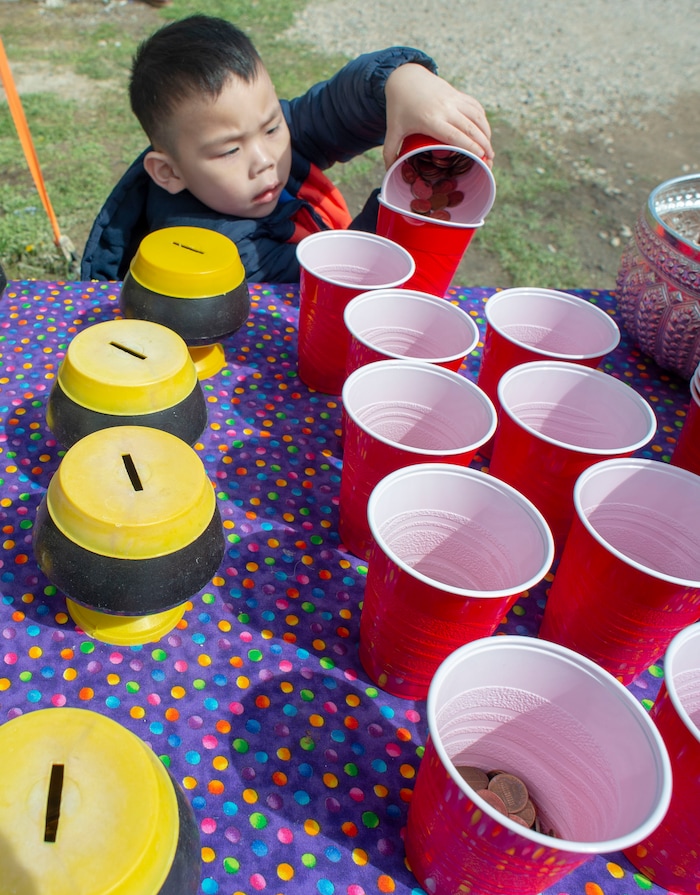 (Rick Egan  |  The Salt Lake Tribune)    Alea Tsone, 4, puts money in the banks for the Buddha, at the Wat Lao Salt Lake Buddharam Utah, New Year Celebration, in West Valley City, Sunday, April 28, 2019.


