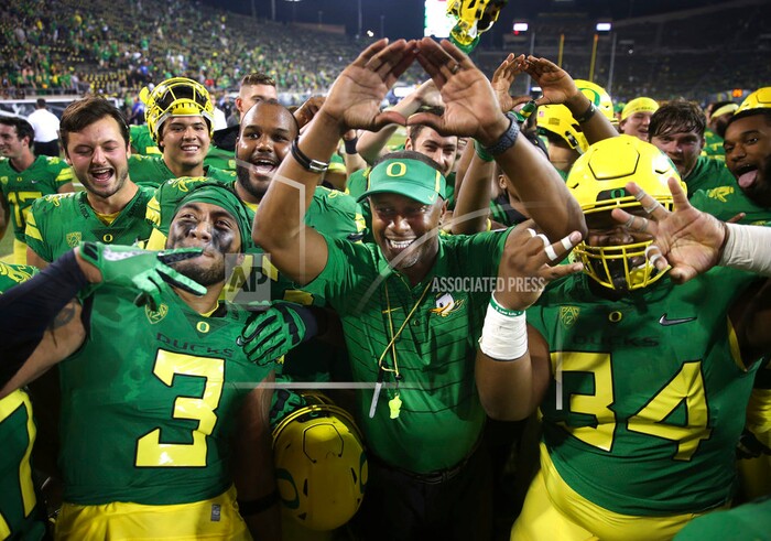 Oregon coach Willie Taggart, center, throws the "O" to fans as he celebrates with his team after a 77-21 victory over Southern Utah in an NCAA college football game Saturday, Sept. 2, 2017, in Eugene, Ore. (AP Photo/Chris Pietsch)
