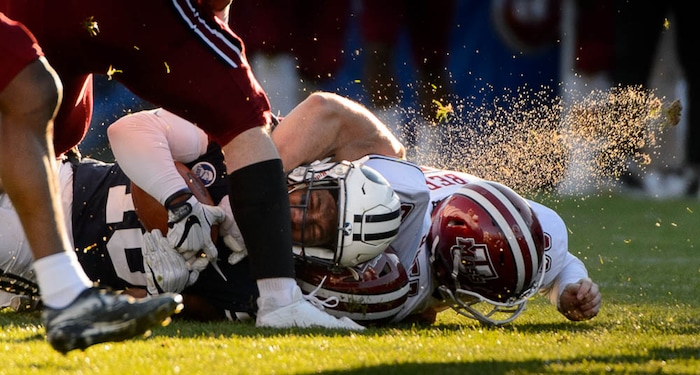 (Trent Nelson | The Salt Lake Tribune)  Brigham Young Cougars defensive back Michael Shelton (18) is tackled by Massachusetts Minutemen defensive lineman Joe Previte (61) as BYU hosts the University of Massachusetts, NCAA football in Provo, Saturday November 18, 2017.