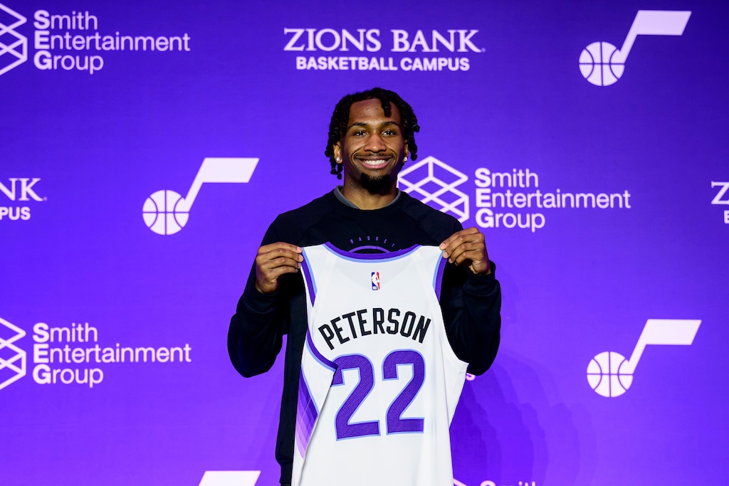 (Tyler Tate | AP) Darryn Peterson holds up his jersey during a press conference for the Utah Jazz No. 2 overall draft selection, Saturday, June 27, 2026, in Salt Lake City.