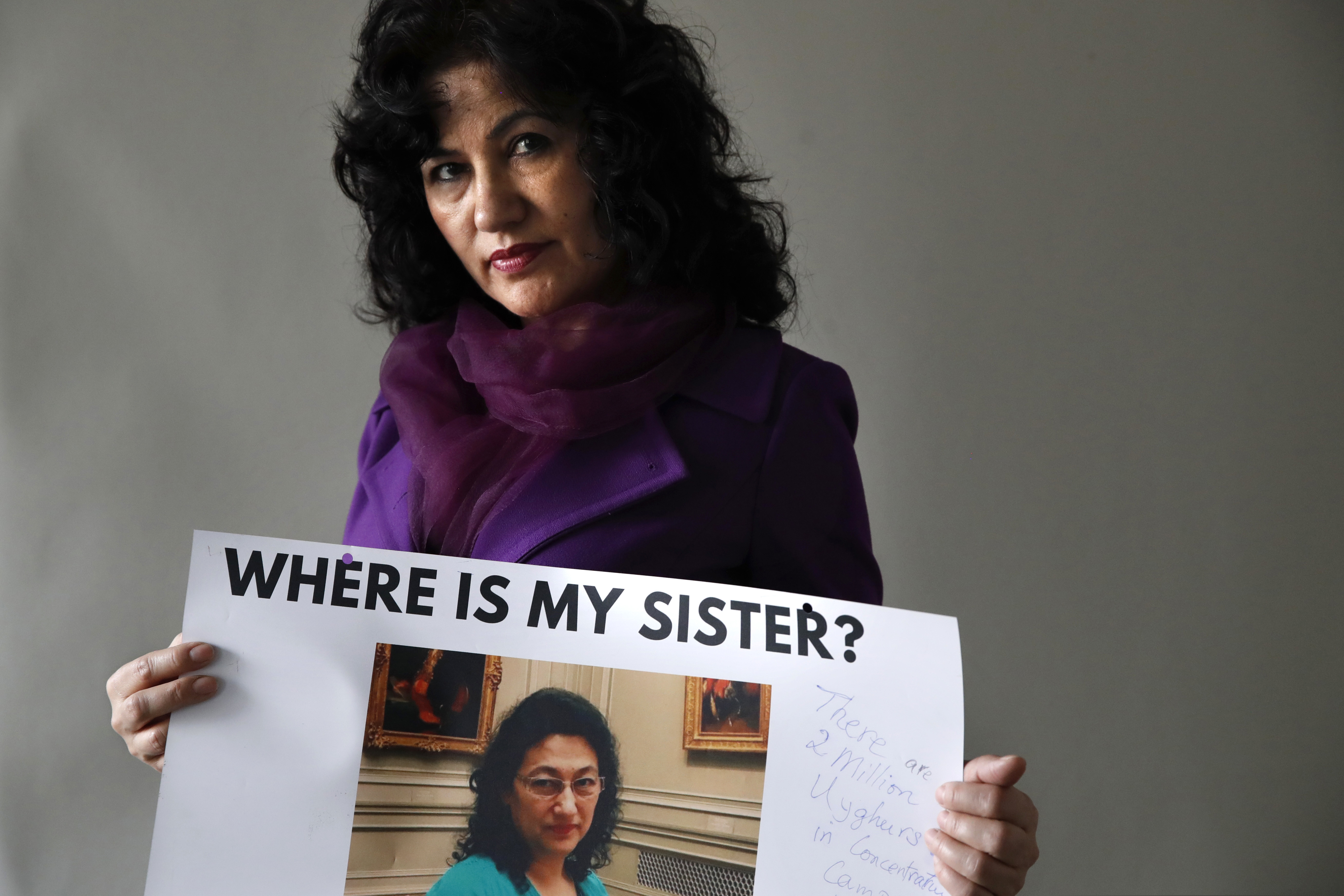 Rushan Abbas, 51, of Herndon, Va., holds a photo of her sister, Gulshan Abbas, Monday, Dec. 17, 2018, in Washington. Rushan Abbas, a Uighur in Washington, D.C., said her sister is among the many Uighurs detained. The sister, Dr. Gulshan Abbas was taken to what the government calls a vocational center, although she has no specific information on whether her sister is being forced to work. (AP Photo/Jacquelyn Martin)