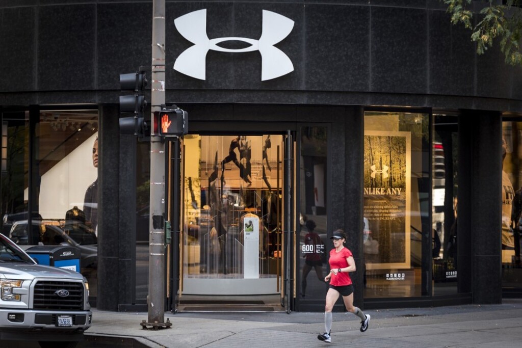 (Christopher Dilts | Bloomberg) Runner passes an Under Armour store in downtown Chicago.