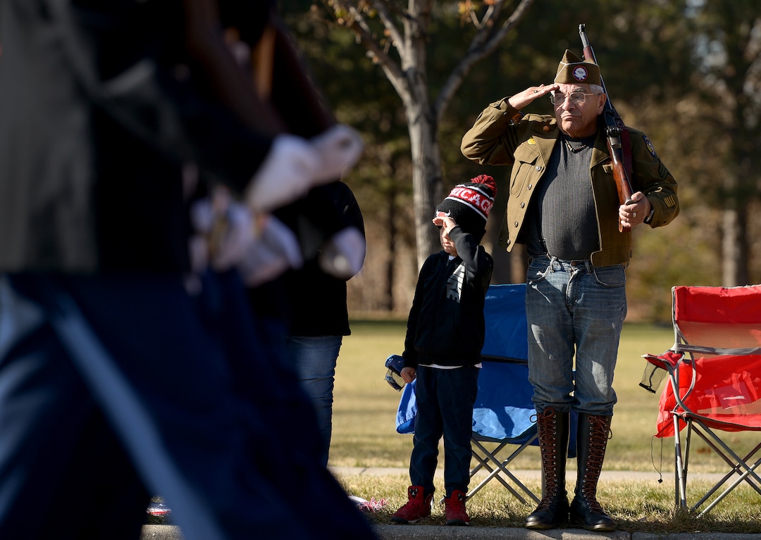 (Leah Hogsten  |  The Salt Lake Tribune)  "I'm here to salute [veterans] and thank them for their service," said Albert Mora, 69, while watching the parade with his grandsons and wife. "They get a kick out of it and so do I." Mora's grandson Adrian, 7, salutes veterans at his side. Mora, an Army Airborne veteran who served in Vietnam, carried his older brother's WWII M-1 Grand rifle. Mora said seven of his eight brothers served in WWII, Korean War and the Vietnam War.  Northern Utah’s 12th Annual Veterans Day Parade Saturday, Nov. 11, 2017 in Layton.