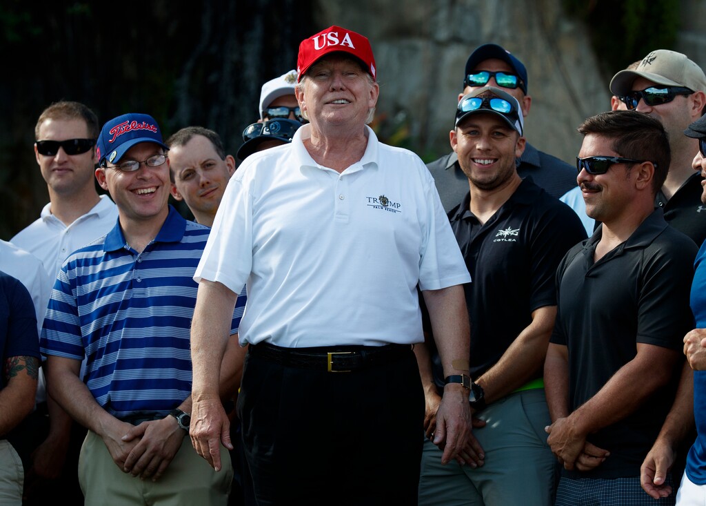 (AP Photo/Evan Vucci, File) In this Dec. 29, 2017, file photo, President Donald Trump smiles as he meets with members of the U.S. Coast Guard, who he invited to play golf, at Trump International Golf Club in West Palm Beach, Fla.