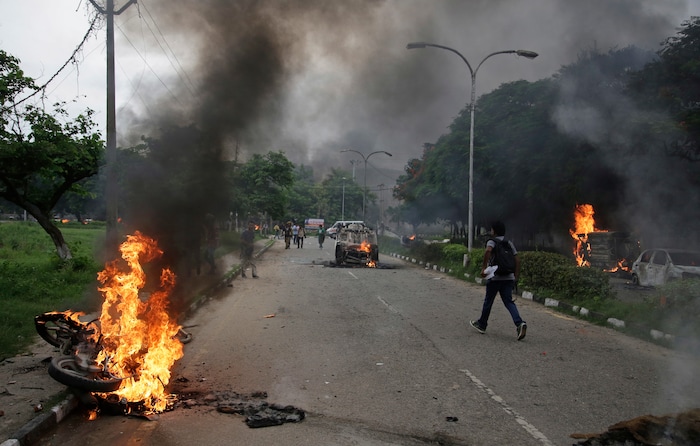 Vehicles set alight by Dera Sacha Sauda sect members burn in the streets of in Panchkula, India, Friday, Aug. 25, 2017. Deadly riots have broken out in a north Indian town after a court convicted a guru of raping two of his followers. Mobs also attacked journalists and set fire to government buildings and railway stations. (AP Photo/Altaf Qadri)