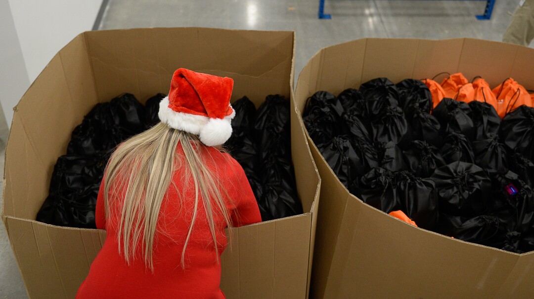 (Francisco Kjolseth  |  The Salt Lake Tribune)  Wendy Reynolds accommodates food bags as USANA staff volunteer their time assembling the bags for at-risk youth at the newly-renovated packing and storage facility next to the headquarters of the Salt Lake City company on Wed. Dec. 11, 2019. The USANA Foundation has acquired two local charities, Kids Next Door and KidsEat!, that provides hundreds of food bags every week for the kids for the weekends and during long school breaks.